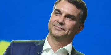 Senador Flávio Bolsonaro sorri durante evento